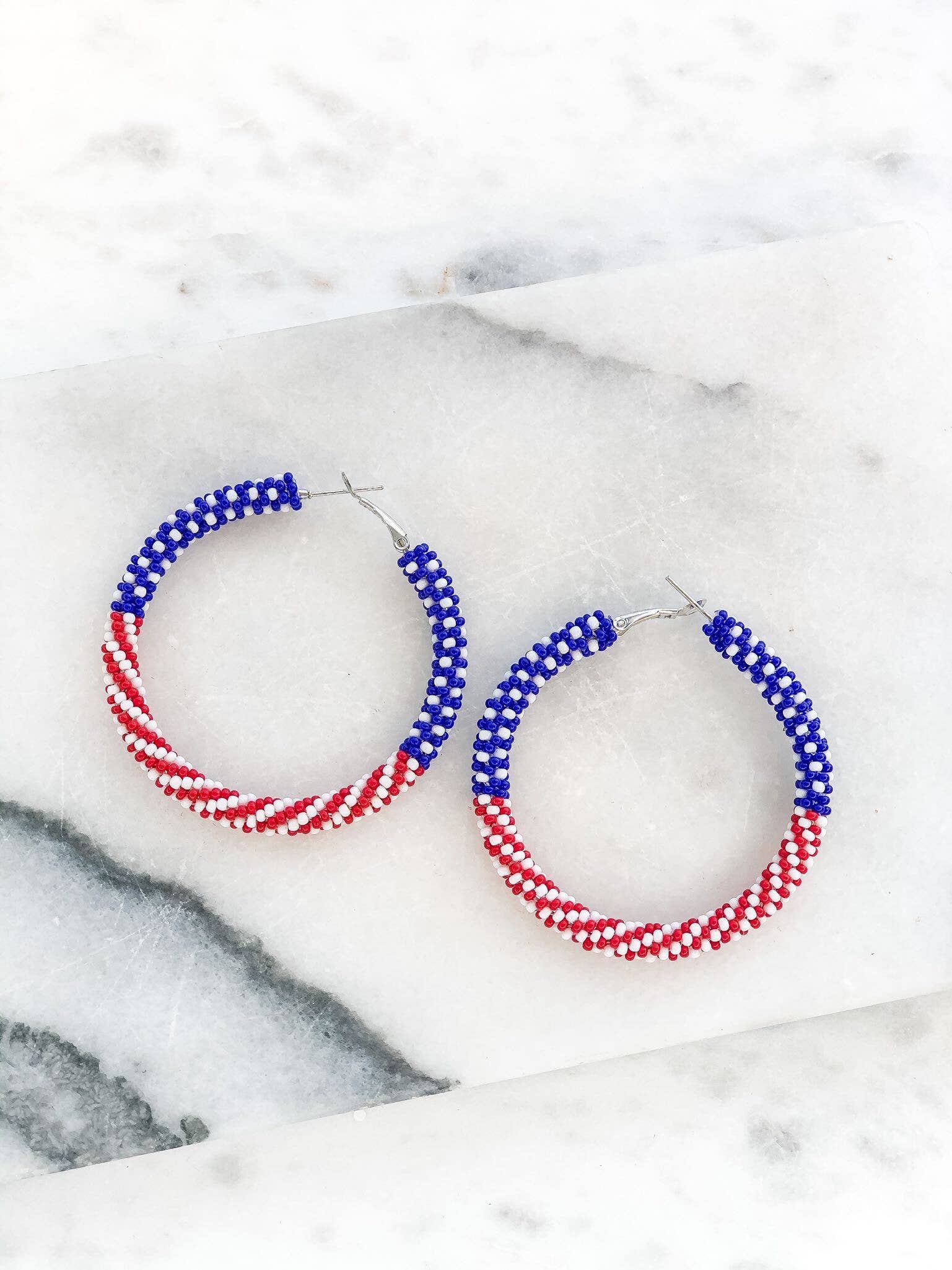 Beaded hoop earrings.  Top half has blue and white beads, representing the stars portion of the flag.  Bottom half has red and white beads, representing the stripes portion of the flag.